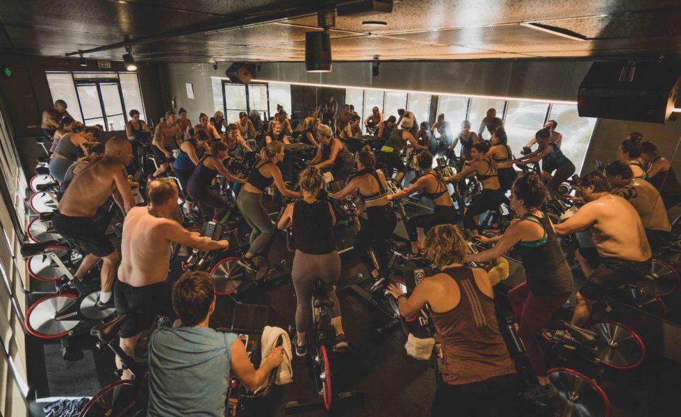 students working out on stationary bikes surrounding an instructor