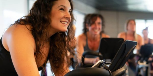 students smiling on stationary bikes